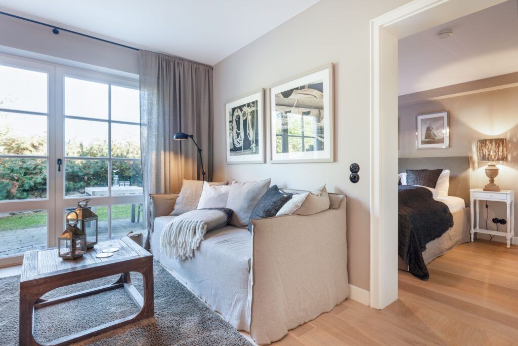Sofa und Blick ins Schlafzimmer in Ferienwohnung auf Sylt